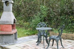 A stone BBQ and patio area with seating. BBQ and patio area.